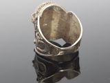 an image of a silver ring sitting on top of a black surface