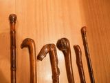 many different types of walking canes on a wooden table