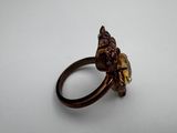 a close up of a ring on a white surface with a brown stone