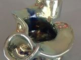 a silver vase with a glass in it on a table