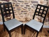deux chaises placées l'une à côté de l'autre devant un mur de pierre