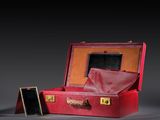 a red suitcase with a mirror in it on a gray surface
