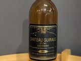 des bouteilles de vin posées sur une table en bois, avec un mur gris en arrière-plan