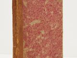 an old book sitting on top of a white table next to a white wall