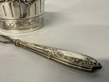 a silver spoon and a silver cup on a table