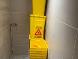 yellow buckets are stacked on top of each other in a bathroom