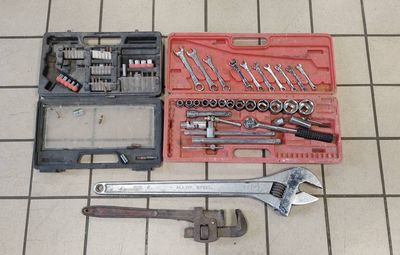 a tool kit sitting on a tiled floor next to a tool box