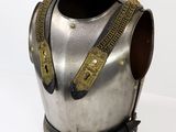 a silver and gold armor on display on a white surface