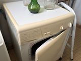 a green vase on top of a washer and dryer