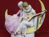 une figurine représentant un homme et une femme assis sur la Lune