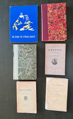 several books are lined up on a table with a black background