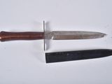 two knives on a white surface one has a wooden handle
