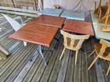 tables and chairs on a wooden deck with a tent in the background