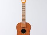 an image of a guitar hanging from a string on a white wall