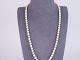 a white pearl necklace on a mannequin display