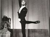 black and white photograph of a woman in a tuxedo doing a ballet pose