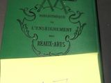 un livre vert sur lequel on voit des inscriptions, posé sur une table