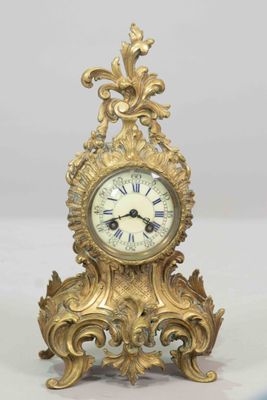 a gold clock sitting on top of a white table