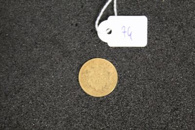 a gold coin and a white tag on a black surface