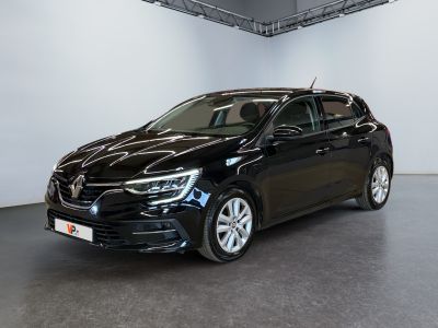 Une voiture noire est garée dans une grande pièce aux murs blancs.