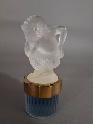 une figurine d'ange posée sur un vase bleu
