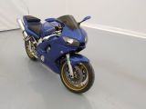 a blue motorcycle parked in a room with a white wall