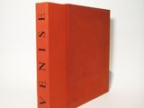 an orange book sitting on top of a white table next to a white wall