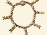 une image représentant un bracelet en or orné de breloques sur fond blanc
