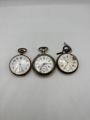 trois types de montres de poche sur une surface blanche