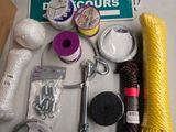supplies laid out on a table including a rope, thread, scissors, and a sign