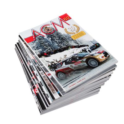 several magazines stacked on top of each other on a white surface