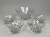 four clear glass bowls and a bowl on a white surface