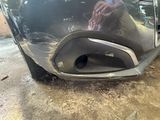 a close up of a car ' s bumper with a person washing it