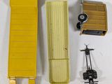 a yellow box truck and other toy items on a white surface