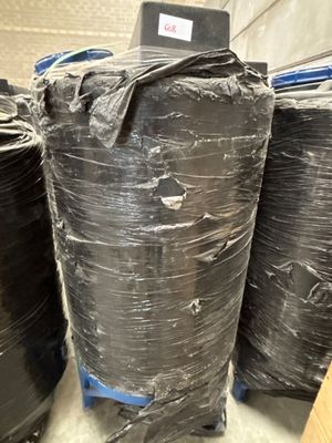 many rolls of black plastic sitting on a pallet