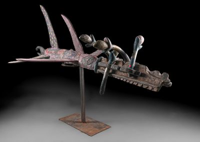 une photo d'une sculpture représentant un oiseau et un bateau, posée sur un socle