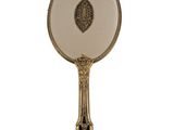 a gold and white hand held mirror on a white background