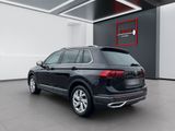 the rear end of a black volkswagen suv parked in a showroom