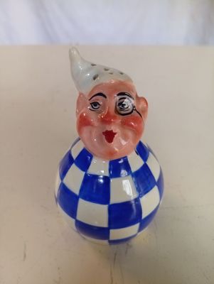 une petite figurine représentant un clown posée sur une table