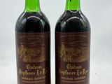 deux bouteilles de vin rouge posées sur une table blanche