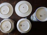 four white and blue china plates and cups on a wooden table