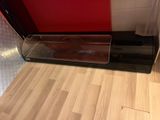 a glass case with a baseball inside of it on a wooden floor