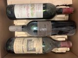 three bottles of wine are in a cardboard box on a table