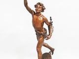 bronze statue of a man holding a bird on a rock