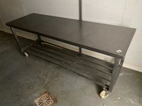 Une table rectangulaire en inox à claies d'entrejambe, sur r…