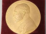 une médaille d'or dans un écrin en velours rouge orné d'un ruban rouge