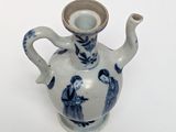 a small blue and white vase with a handle on it