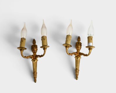 pair of brass wall sconces with white glass shades