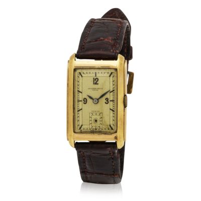 a gold plated wrist watch with brown leather strap