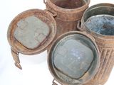 three old tins that are sitting on a table